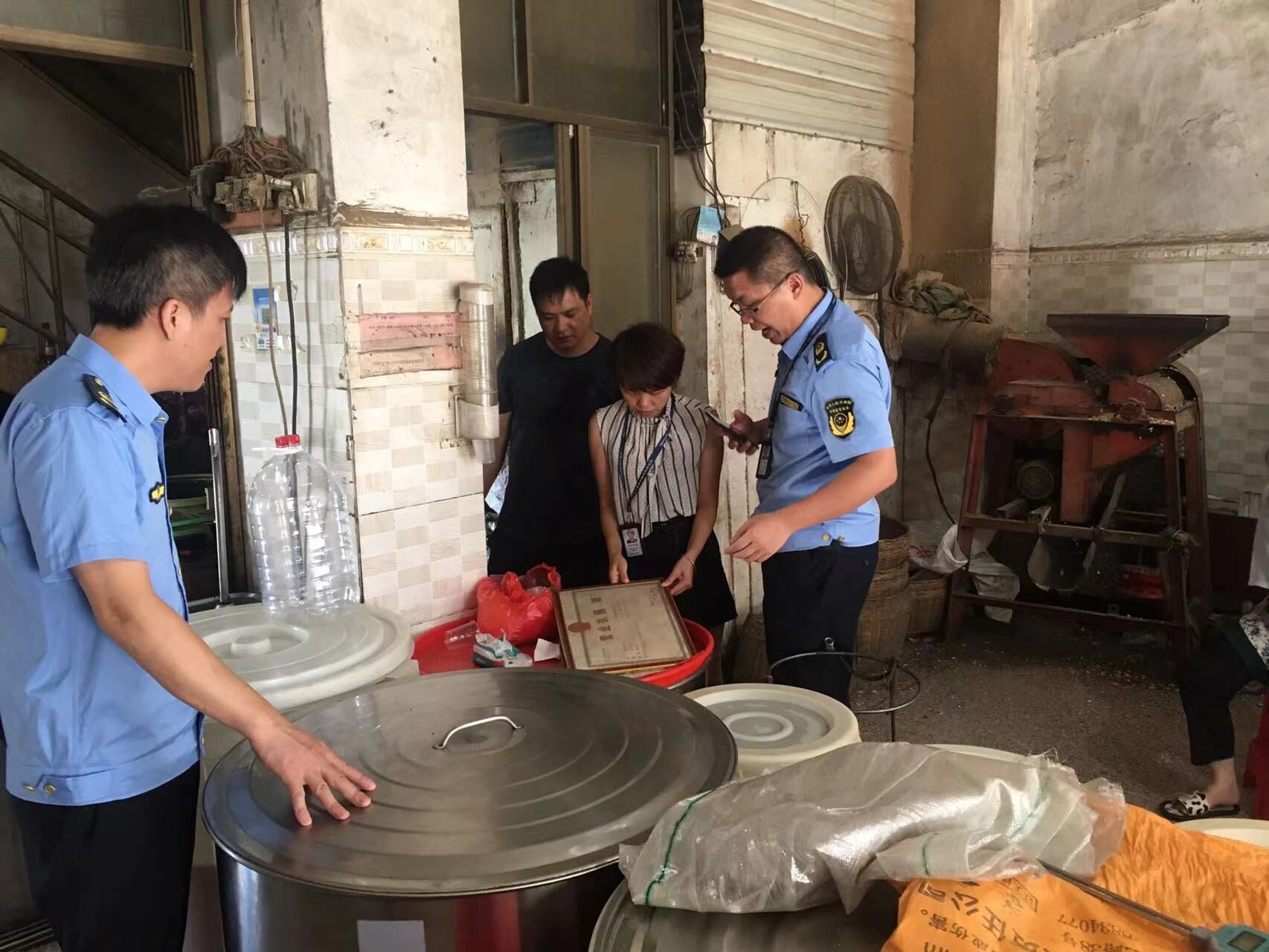 执法人员正在查看榨油小作坊营业执照.jpg